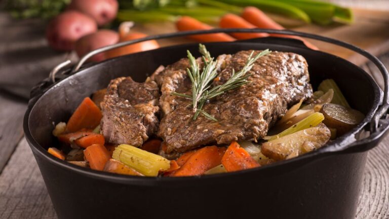 carne de panela pronta em um ponte preto com legumes e batata