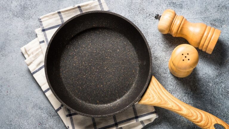 panela antiaderente na mesa em cima de um pano com cabo de madeira